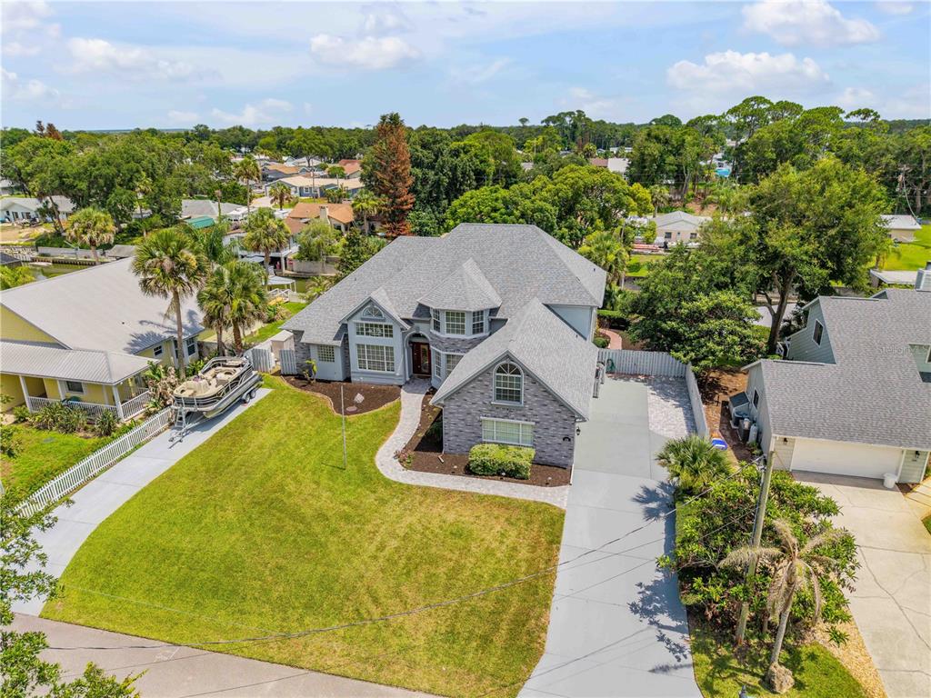 A two-story brick house with a gray shingled roof and a front lawn — 128 GODFREY ROAD, EDGEWATER, FL