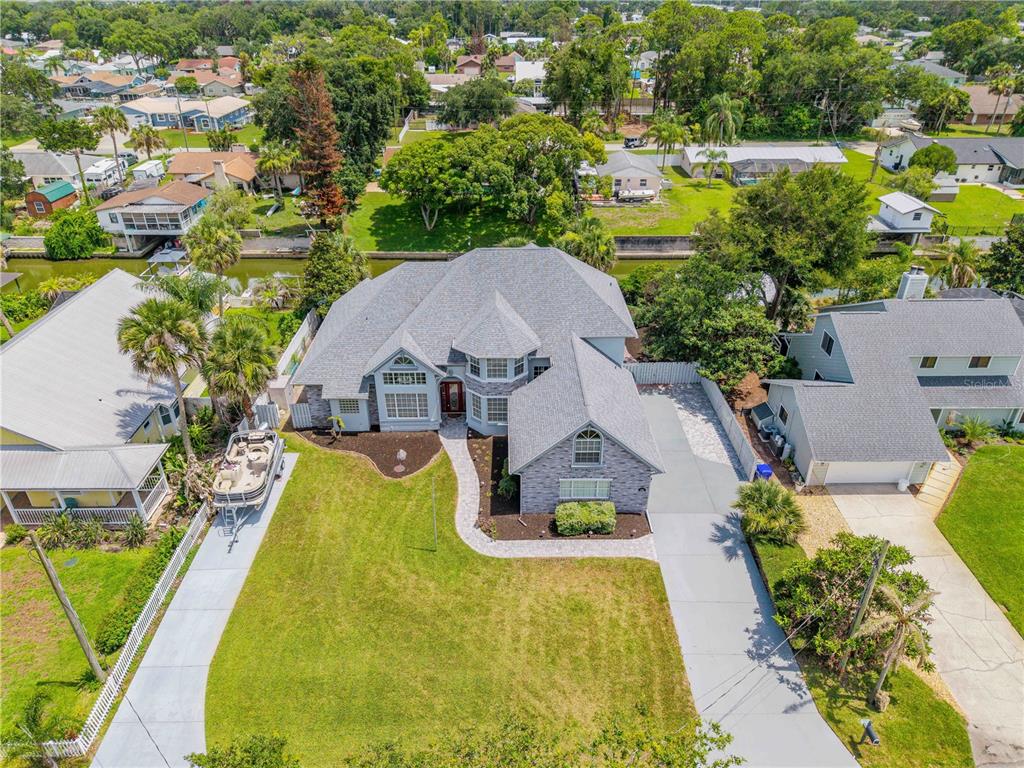An aerial view of a gray brick house with a large lawn and paved driveway — 128 GODFREY ROAD, EDGEWATER, FL