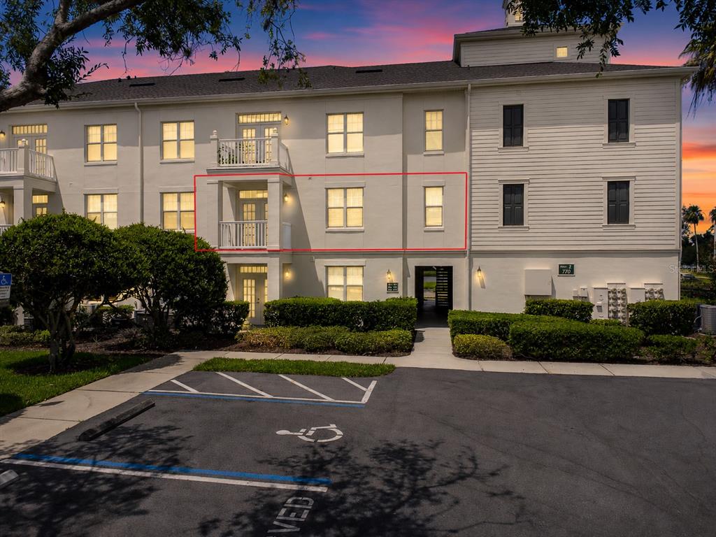 An exterior view of a multi-story apartment building with a red outline highlighting a unit — 770 SIENA PALM DRIVE UNIT 206, CELEBRATION, FL
