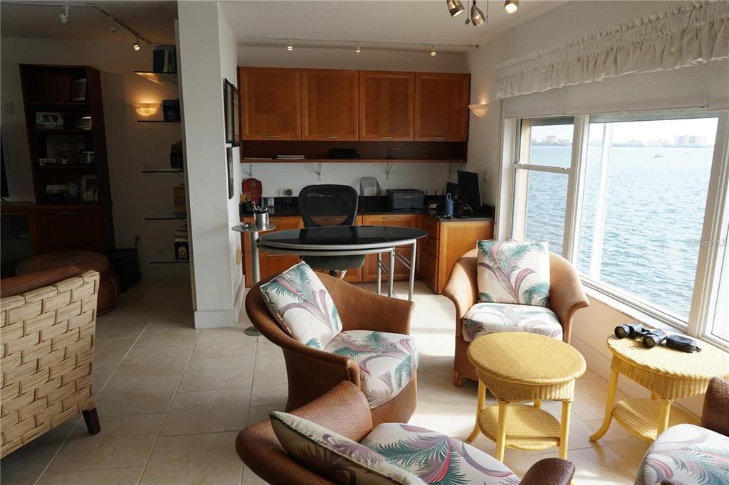 A home office area with wooden cabinets and a desk overlooks a large body of water — 5900 SHORE BOULEVARD S UNIT 402, GULFPORT, FL