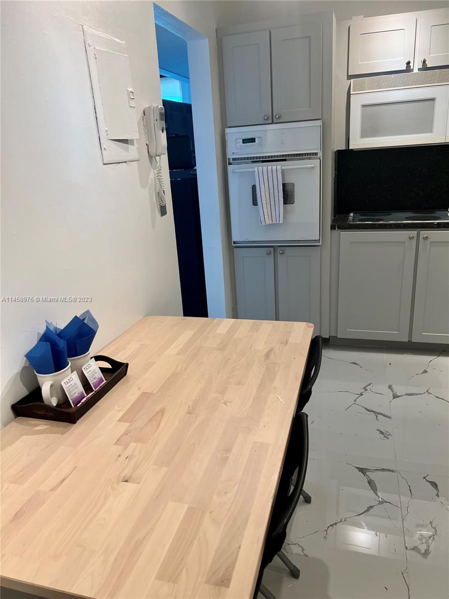 A kitchen features light wood cabinets, a wall oven, and a light wood dining table — 3801 S Ocean Dr # 6S, Hollywood FL 33019, HOLLYWOOD, FL