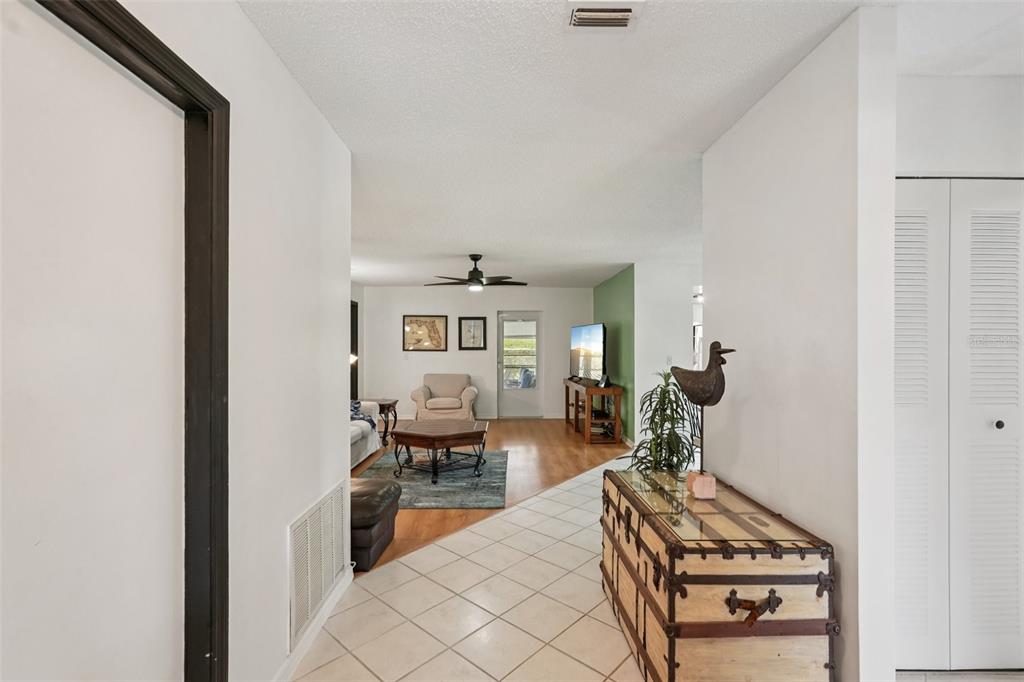 A tiled entryway leads into a living room with wood-look flooring and a ceiling fan — 1604 LELAND DRIVE, SUN CITY CENTER, FL
