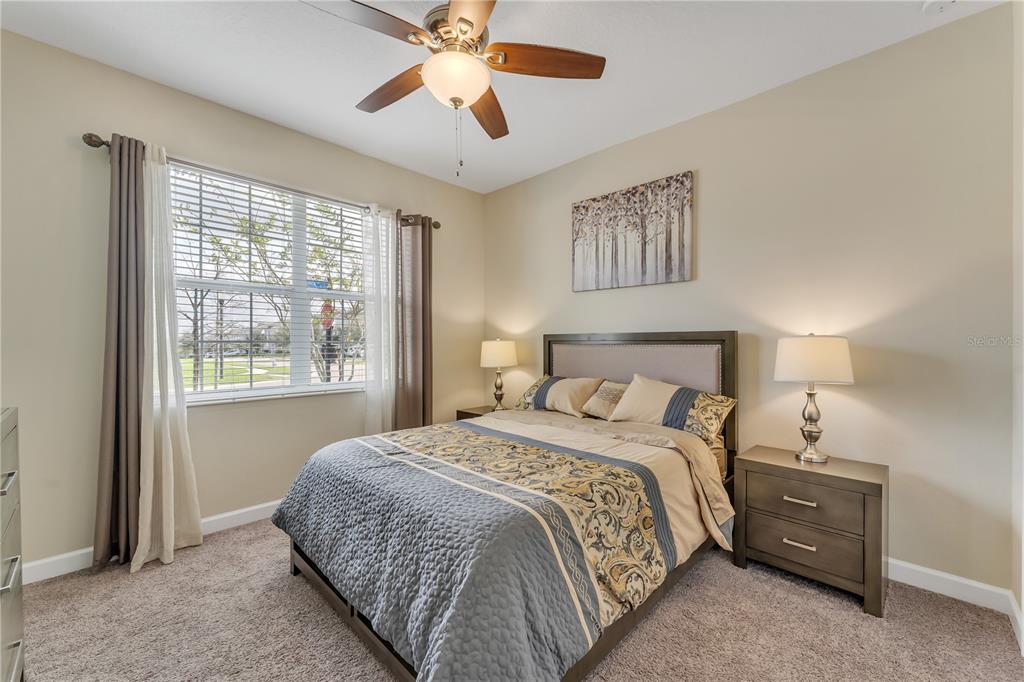A bedroom features a queen bed, two nightstands with lamps, and a window with curtains — 1592 FLANGE DRIVE, DAVENPORT, FL