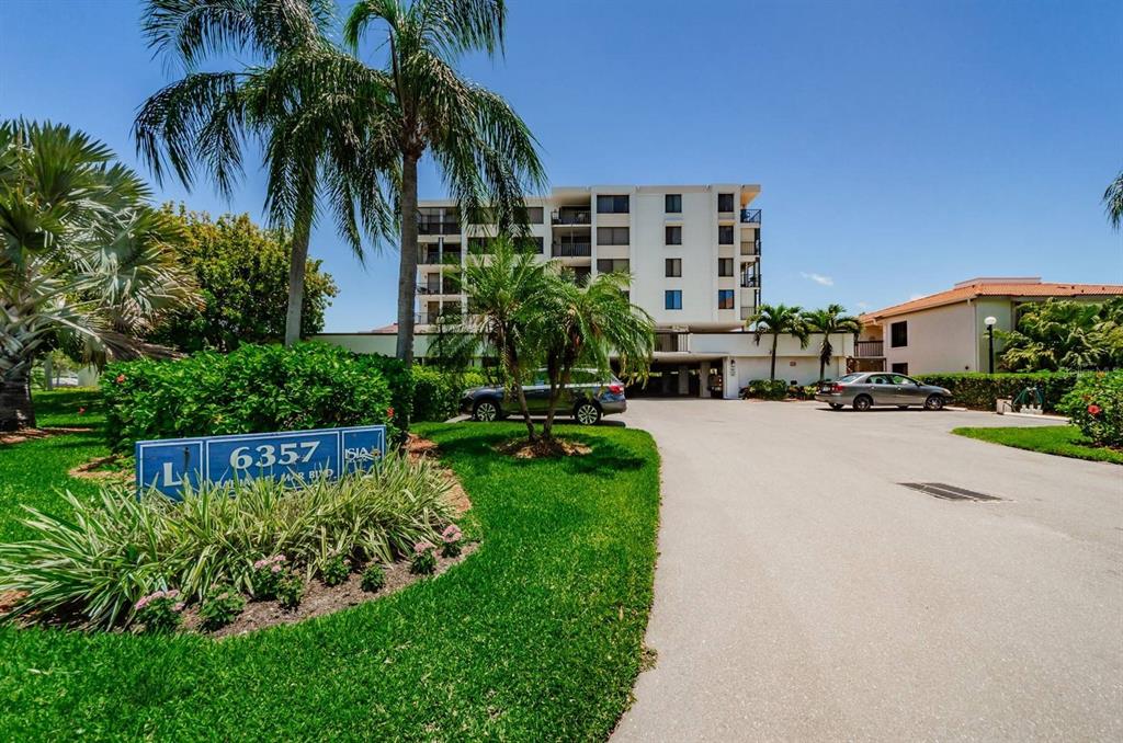 A multi-story apartment building stands behind a landscaped sign and a paved driveway — 6357 BAHIA DEL MAR BOULEVARD UNIT 408, ST PETERSBURG, FL