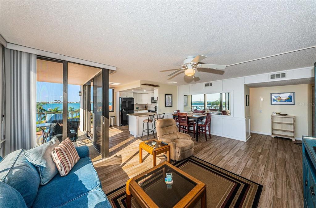 An open-concept living and dining area with tile floors, a balcony, and water views — 6357 BAHIA DEL MAR BOULEVARD UNIT 408, ST PETERSBURG, FL