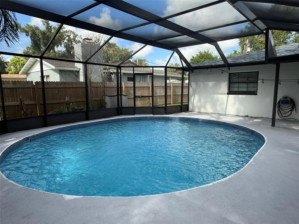 A round swimming pool is enclosed by a screened-in lanai with a concrete deck — 1008 N BRACEWELL DRIVE, PLANT CITY, FL