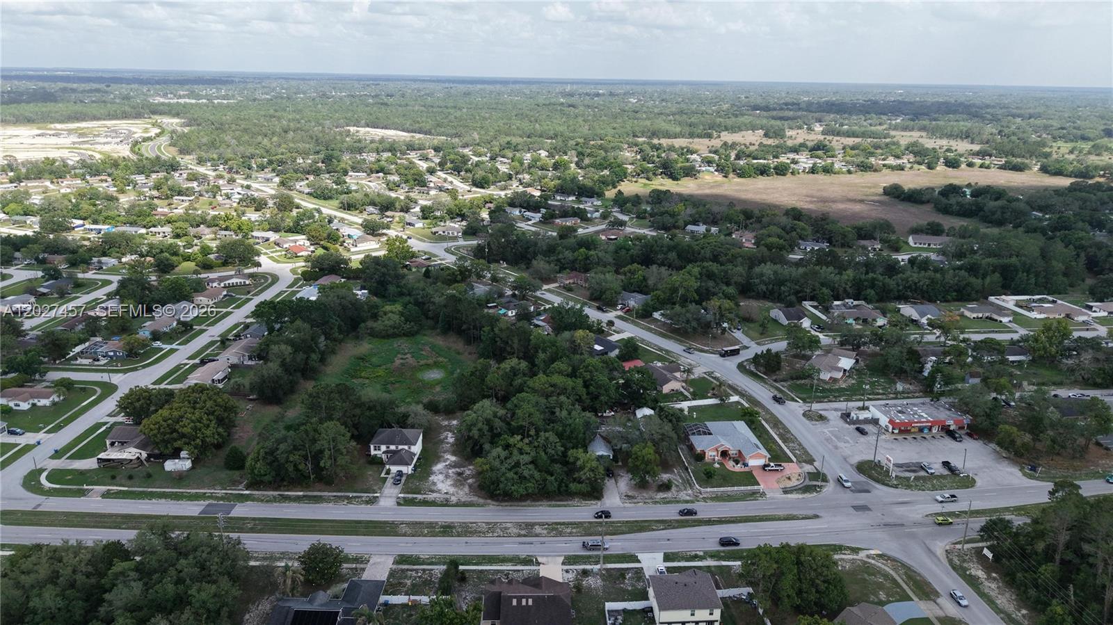 An aerial view shows a residential neighborhood with houses, wooded areas, and a commercial building — 4164 DELTONA BLVD, Spring Hill FL 34606, SPRING HILL, FL