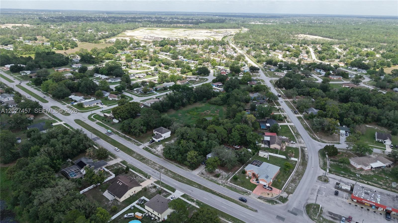 An aerial view shows a residential neighborhood with houses, trees, and intersecting paved roads — 4164 DELTONA BLVD, Spring Hill FL 34606, SPRING HILL, FL