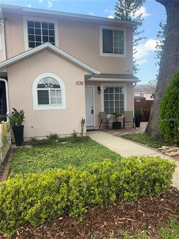 A kitchen features white cabinets, stainless steel appliances, a sink under a window, and tile flooring — 6738 MAGNOLIA POINTE CIRCLE, ORLANDO, FL
