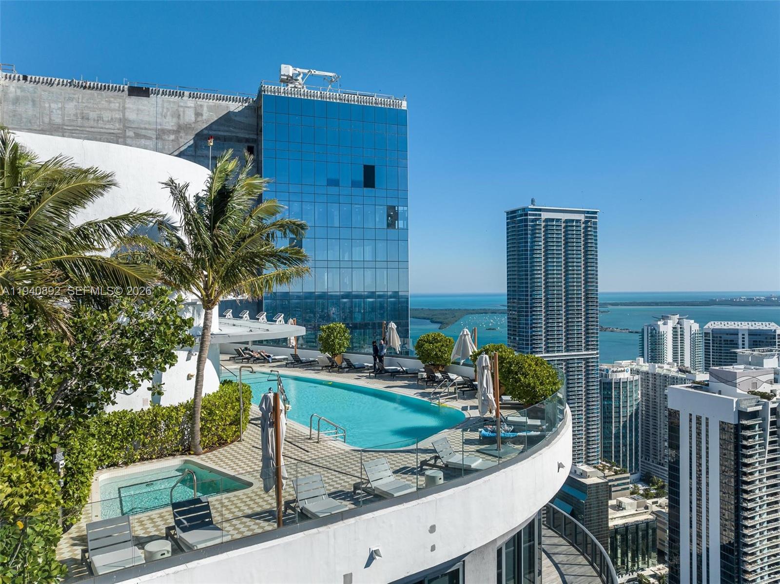 An elevated outdoor pool deck features lounge chairs, umbrellas, and views of surrounding city skyscrapers — 801 S Miami Ave # 2905, Miami FL 33130, MIAMI, FL