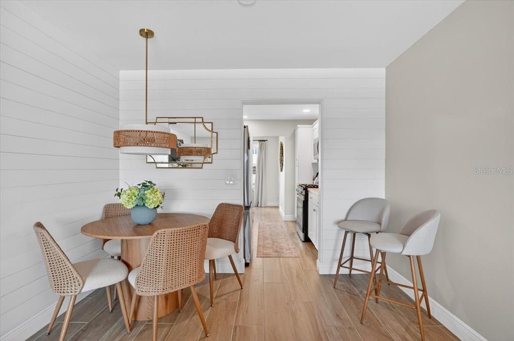A living room with a sectional sofa, two blue armchairs, and a dining area — 2960 59TH STREET S UNIT 310, GULFPORT, FL