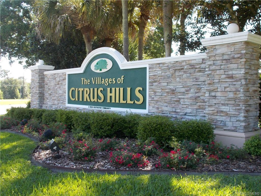 A stone monument sign for The Villages of Citrus Hills stands in a landscaped garden — 1567 E CLEVELAND STREET, HERNANDO, FL