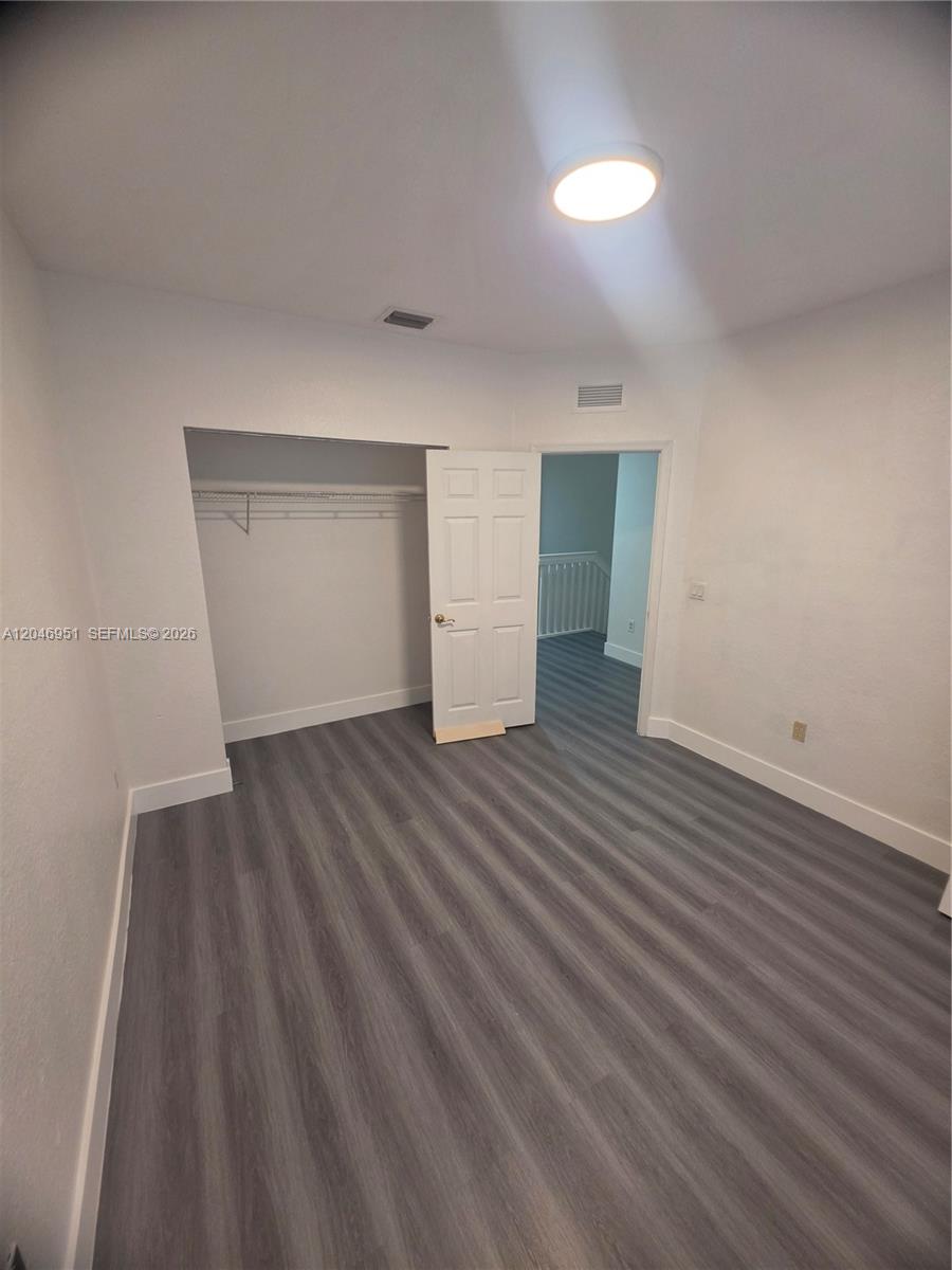 This bedroom features gray wood-look flooring, white walls, a closet, and a ceiling light — 2532 SW 85th Ter # 102, Miramar FL 33025, MIRAMAR, FL