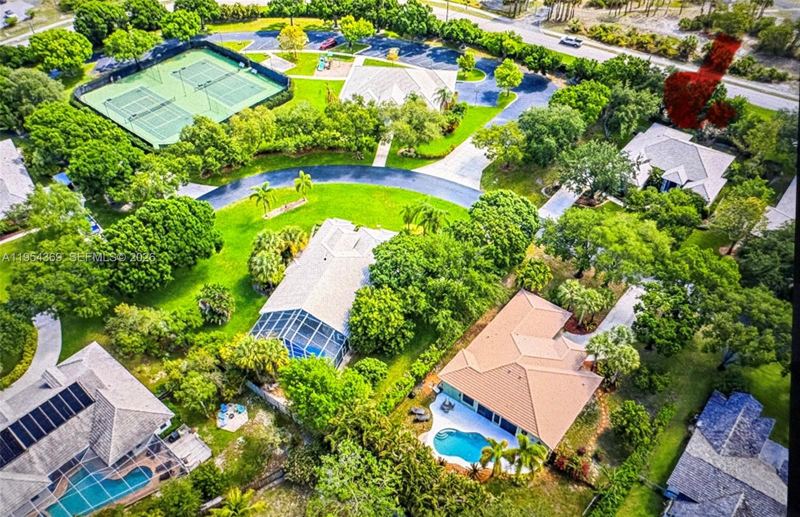 An aerial view shows several houses with swimming pools and a tennis court nearby — 18265 SE Ridgeview Dr, Tequesta FL 33469, TEQUESTA, FL