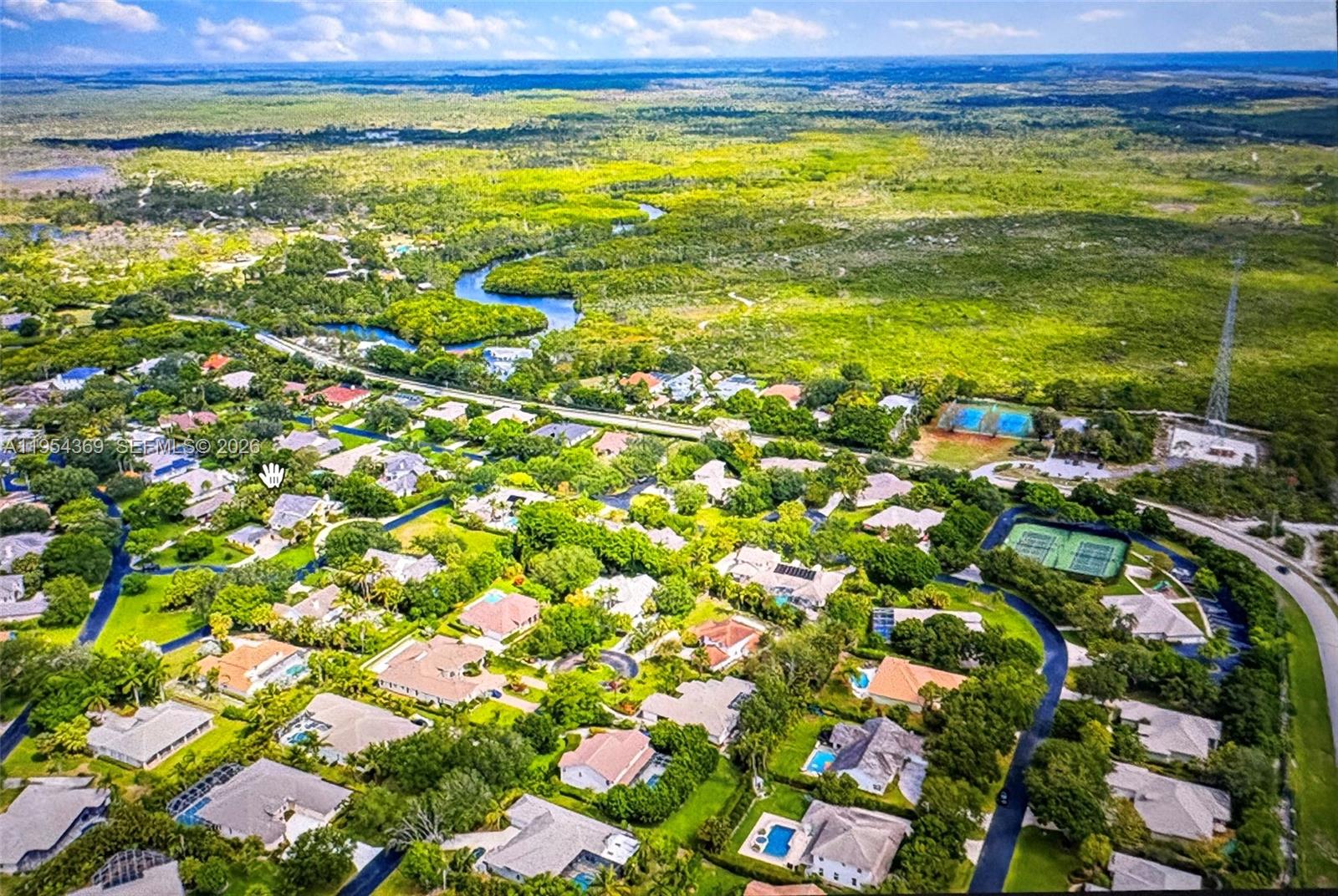 An aerial view shows a suburban neighborhood with houses, swimming pools, and surrounding green space — 18265 SE Ridgeview Dr, Tequesta FL 33469, TEQUESTA, FL