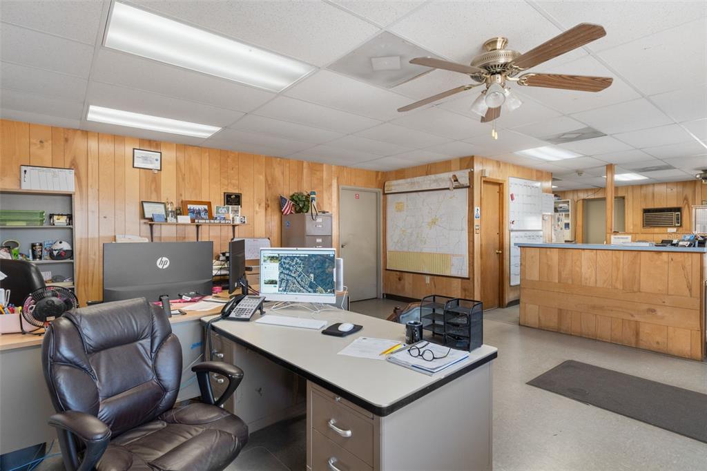 An office space features wood-paneled walls, a drop ceiling, a desk, and a service counter — 6331 & 6275 S TEX POINT, HOMOSASSA, FL