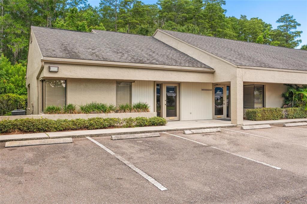A single-story commercial building with a beige stucco exterior and a parking lot in front — 2424 ENTERPRISE ROAD UNIT A, CLEARWATER, FL