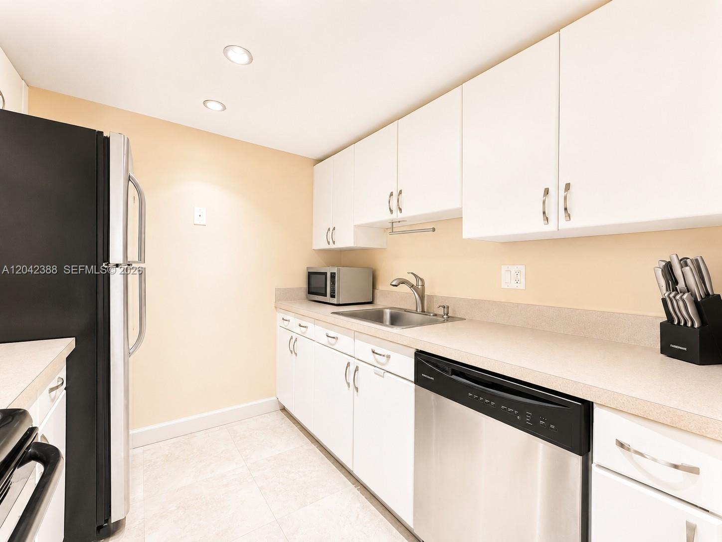 A kitchen features white cabinets, stainless steel appliances, and light-colored countertops — 14421 N Kendall Dr # 000, Miami FL 33186, MIAMI, FL