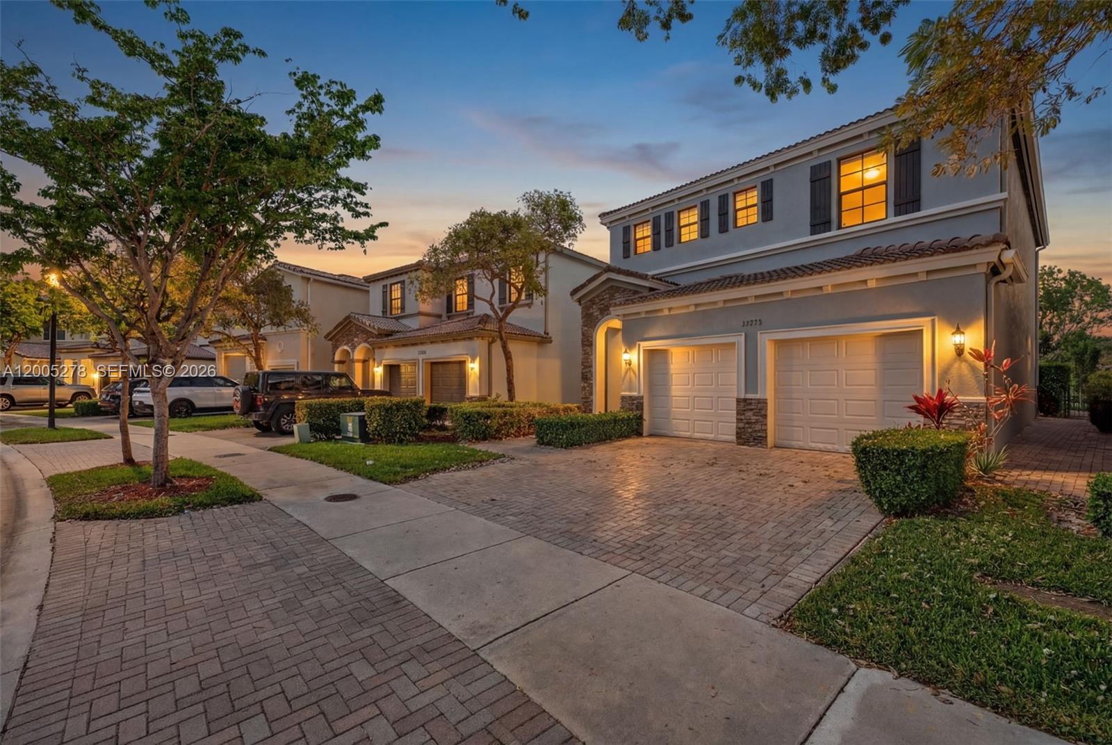 A two-story house with a two-car garage and a paved driveway at dusk — 19278 NE 6th Ave, Miami FL 33179, MIAMI, FL