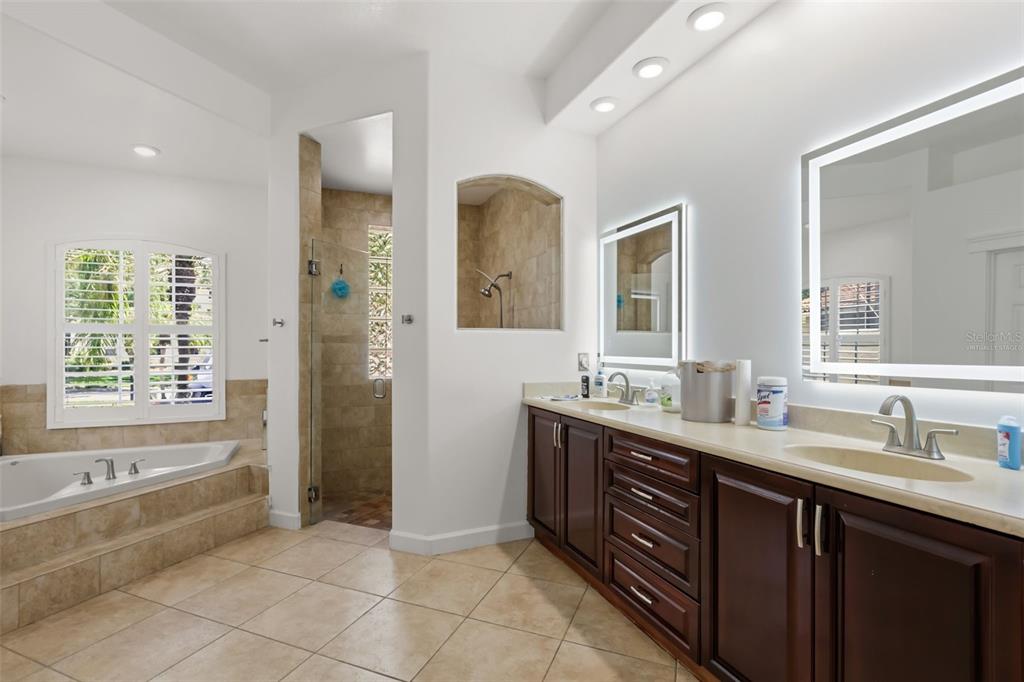 A bathroom features a soaking tub, a walk-in shower, and a double vanity with mirrors — 2724 NORTHAMPTON AVENUE, ORLANDO, FL