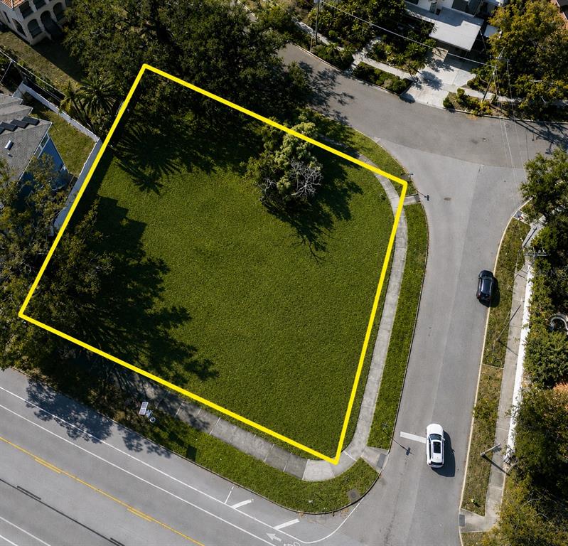 An aerial view shows a vacant, grass-covered corner lot outlined in yellow — 116 W DAVIS BOULEVARD, TAMPA, FL