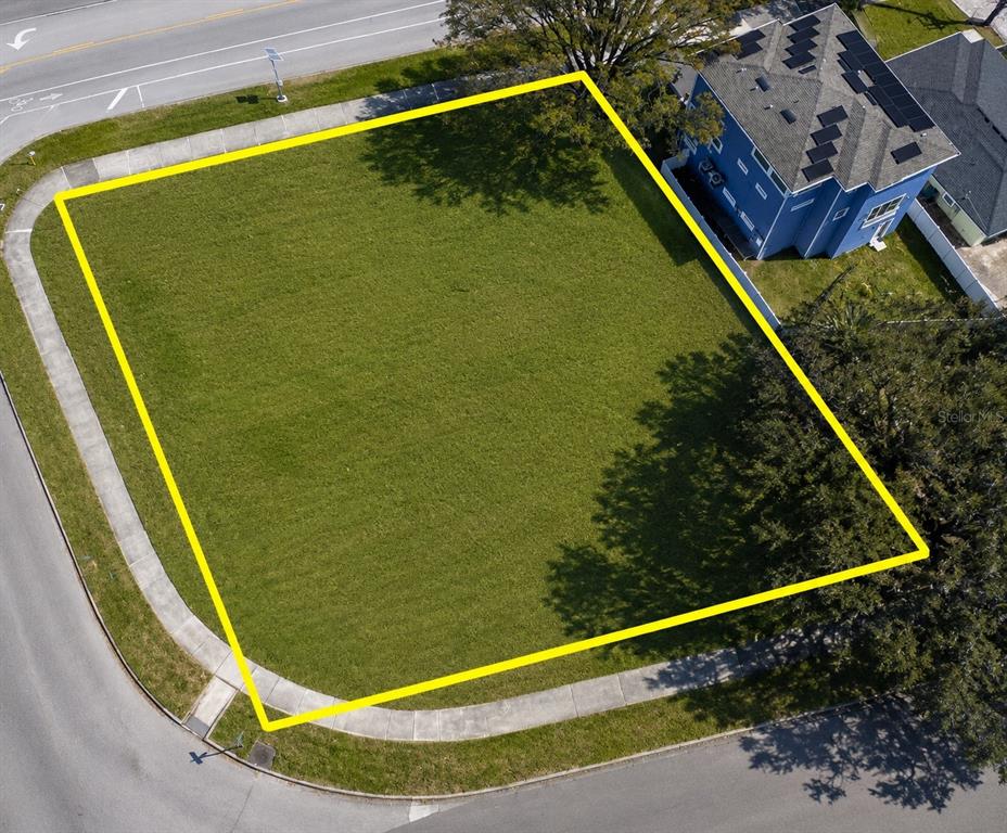 An aerial view shows a vacant, rectangular grass lot outlined in yellow near a house — 116 W DAVIS BOULEVARD, TAMPA, FL