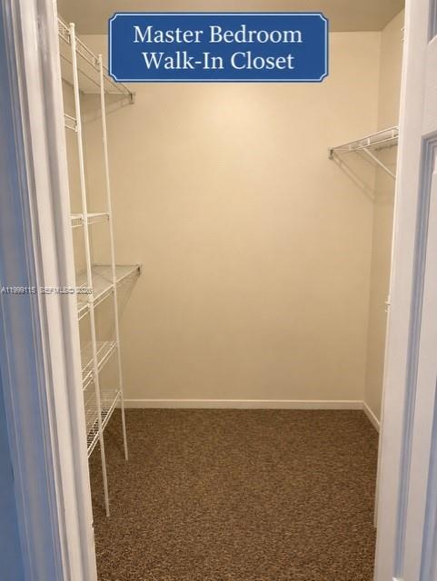 A walk-in closet features white wire shelving units and tan carpeted flooring — 22105 SW 103rd Ct, Cutler Bay FL 33190, CUTLER BAY, FL