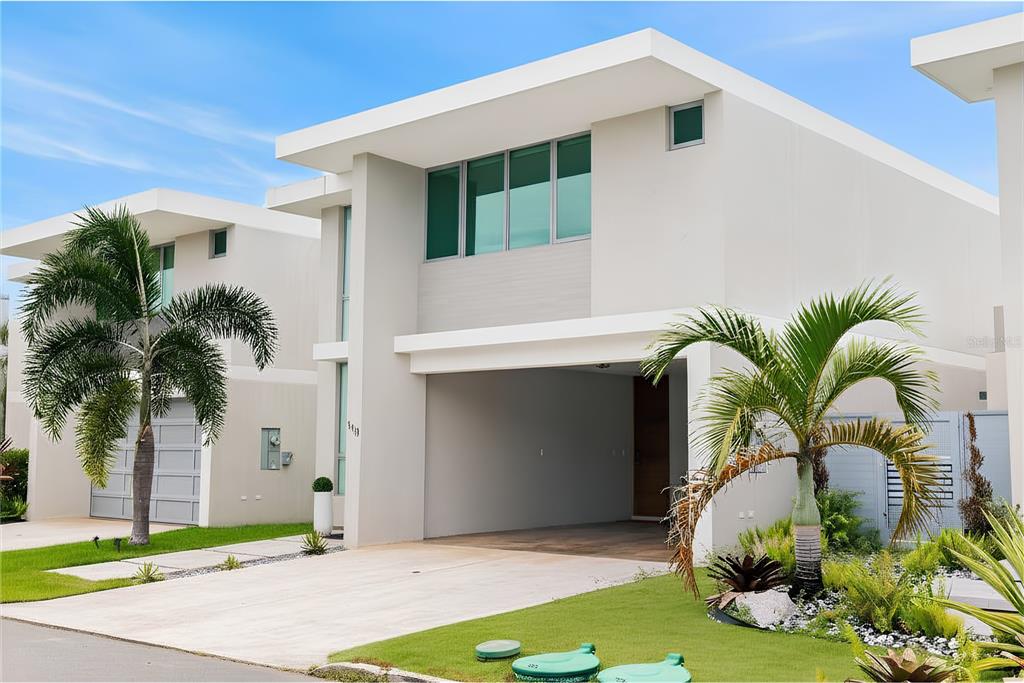 A modern two-story house with a flat roof, open carport, and palm trees in front — 110 CENTRAL PARK, RIVIERA VILLAGE, BAYAMON, PR
