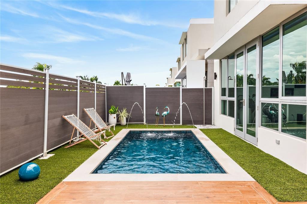 A small rectangular swimming pool sits in a backyard with artificial turf and privacy fencing — 110 CENTRAL PARK, RIVIERA VILLAGE, BAYAMON, PR