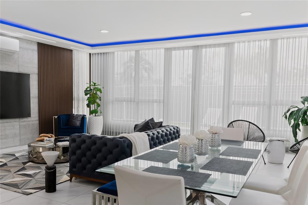 A modern living and dining area features a tufted sofa, glass table, and blue lighting — 110 CENTRAL PARK, RIVIERA VILLAGE, BAYAMON, PR