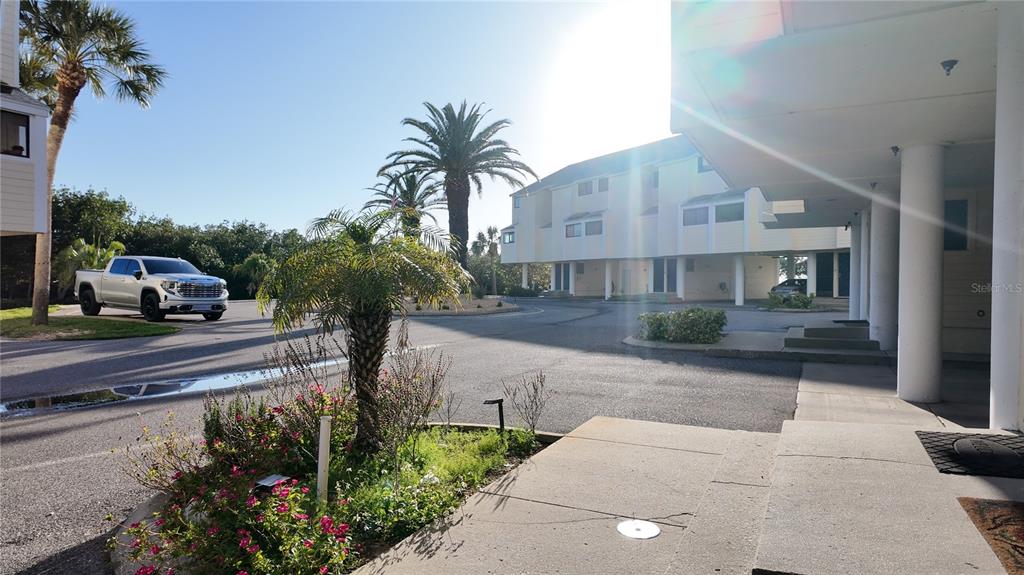 An elevated view shows two multi-story residential buildings with light siding near a body of water — 1500 SUNSET RD BLDG C UNIT C7, TARPON SPRINGS, FL