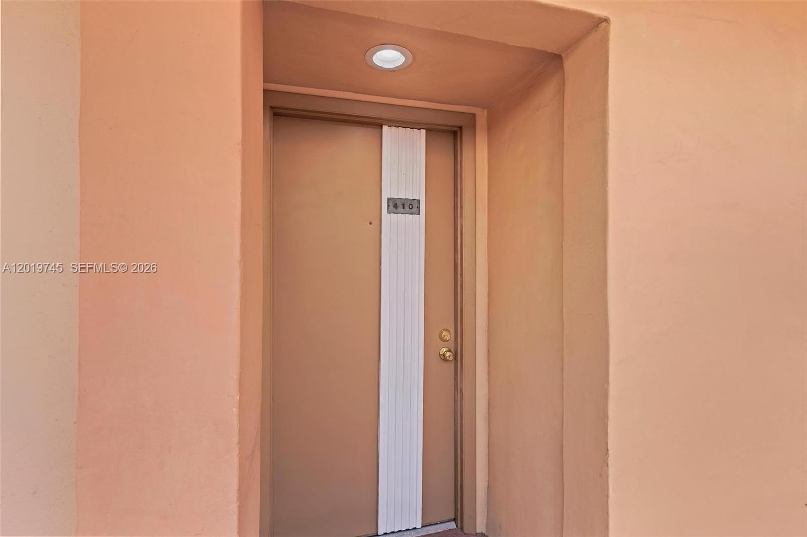 A tiled hallway leads to a living area with a balcony and an adjacent kitchen — 8600 SW 133rd Ave Rd # 410, Miami FL 33183, MIAMI, FL
