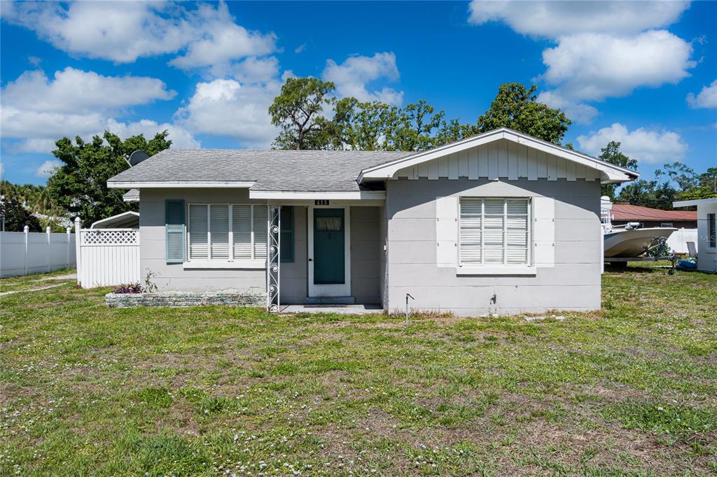 A single-story gray house with a white trim and a front yard under a blue sky — 415 20TH AVENUE W, PALMETTO, FL