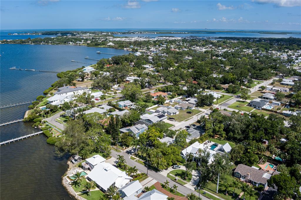 An aerial view shows waterfront homes with docks along a bay in a residential neighborhood — 415 20TH AVENUE W, PALMETTO, FL