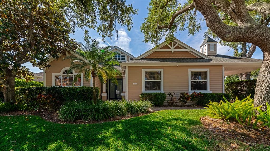 A single-story house with tan siding, a palm tree, and a large oak tree — 309 AMERICAS CUP BOULEVARD, BRADENTON, FL