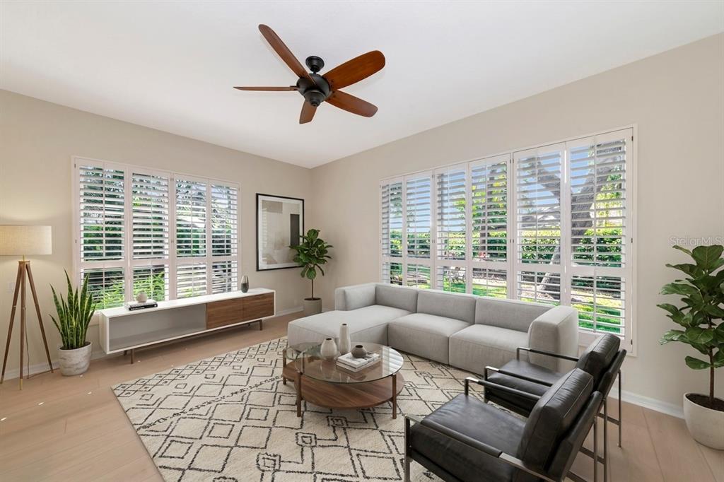 A living room features a sectional sofa, two leather chairs, a ceiling fan, and shutters — 309 AMERICAS CUP BOULEVARD, BRADENTON, FL