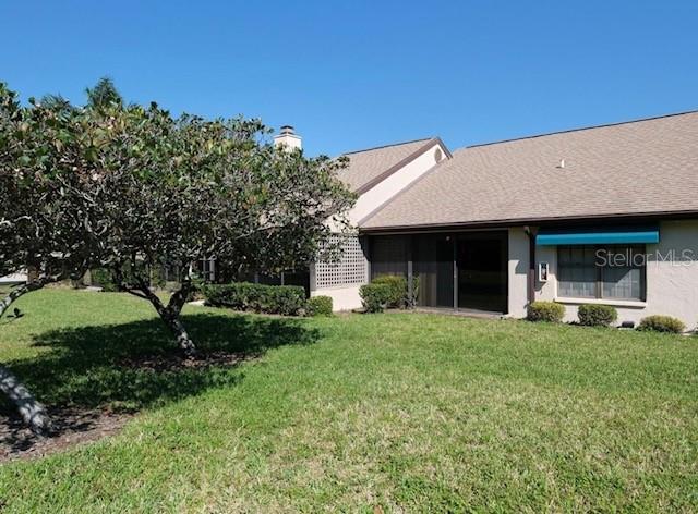 A single-story house with a tan roof and beige exterior sits behind a green lawn — 5924 CLUBSIDE DRIVE, SARASOTA, FL