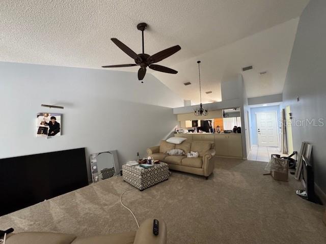 A living room with a vaulted ceiling, ceiling fan, beige sofa, and carpeted flooring — 5924 CLUBSIDE DRIVE, SARASOTA, FL