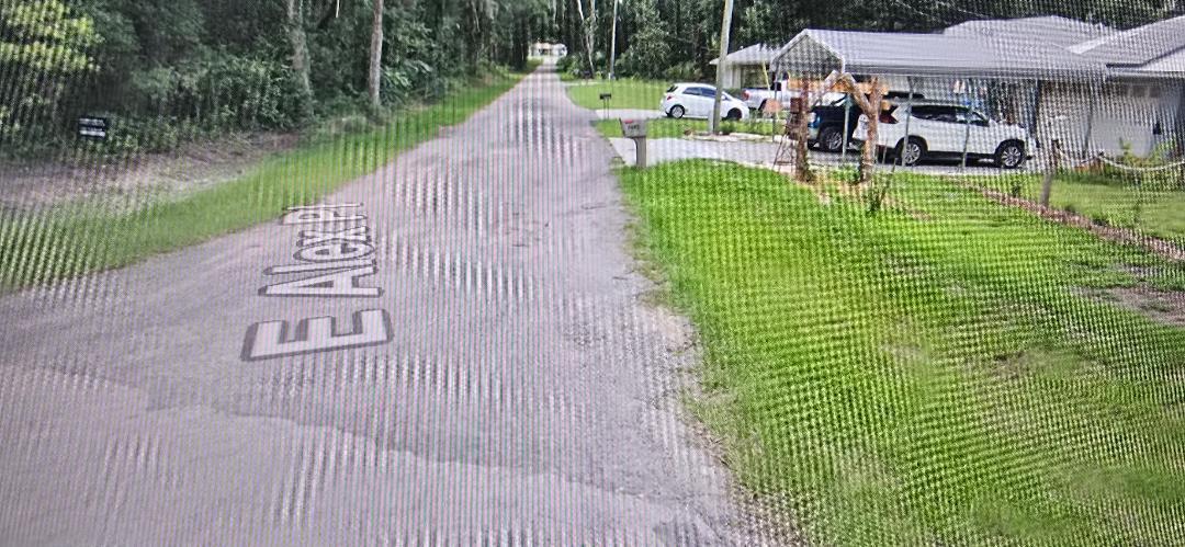 A paved residential street with a house and parked cars on the right side — 3397 E Alex Place, Inverness FL 34453, INVERNESS, FL
