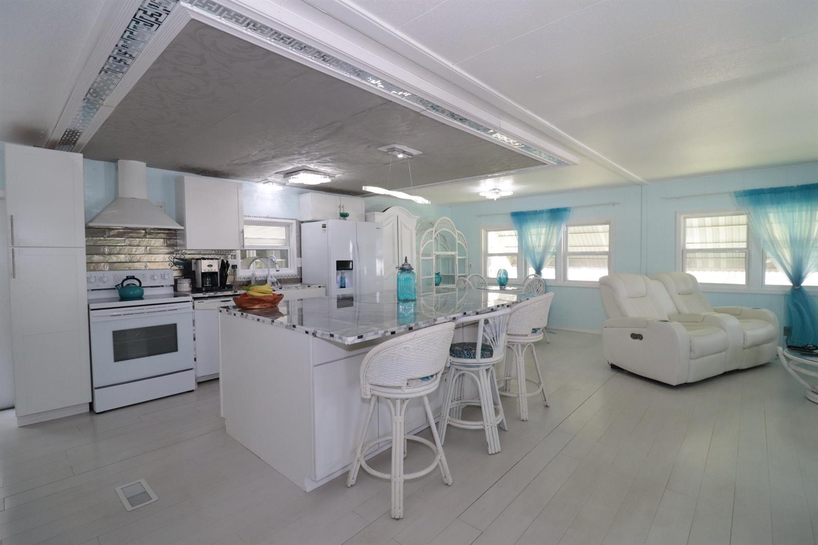 A kitchen with a large island, white cabinetry, and a textured ceiling with decorative trim — 1011 Andros, Boynton Beach FL 33436, BOYNTON BEACH, FL