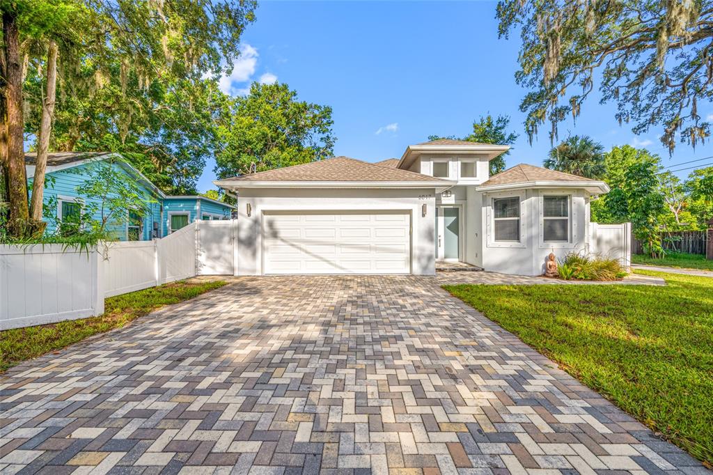 A single-story house with a white exterior, a paved driveway, and a two-car garage — 6017 ADAMS STREET, NEW PORT RICHEY, FL