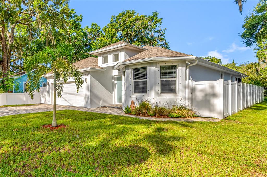 A single-story house with a white exterior, a two-car garage, and a white privacy fence — 6017 ADAMS STREET, NEW PORT RICHEY, FL