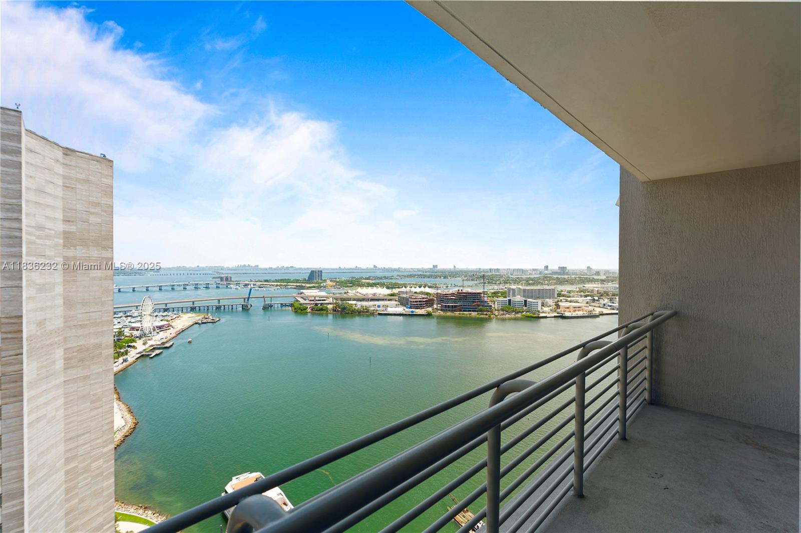 A high-rise balcony overlooks a bay with a bridge, marina, and city skyline — 335 S Biscayne Blvd # 3410, Miami FL 33131, MIAMI, FL
