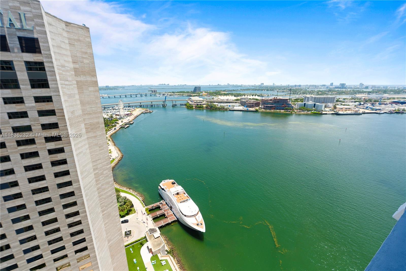 An aerial view shows a large yacht docked near a tall building by the water — 335 S Biscayne Blvd # 3410, Miami FL 33131, MIAMI, FL