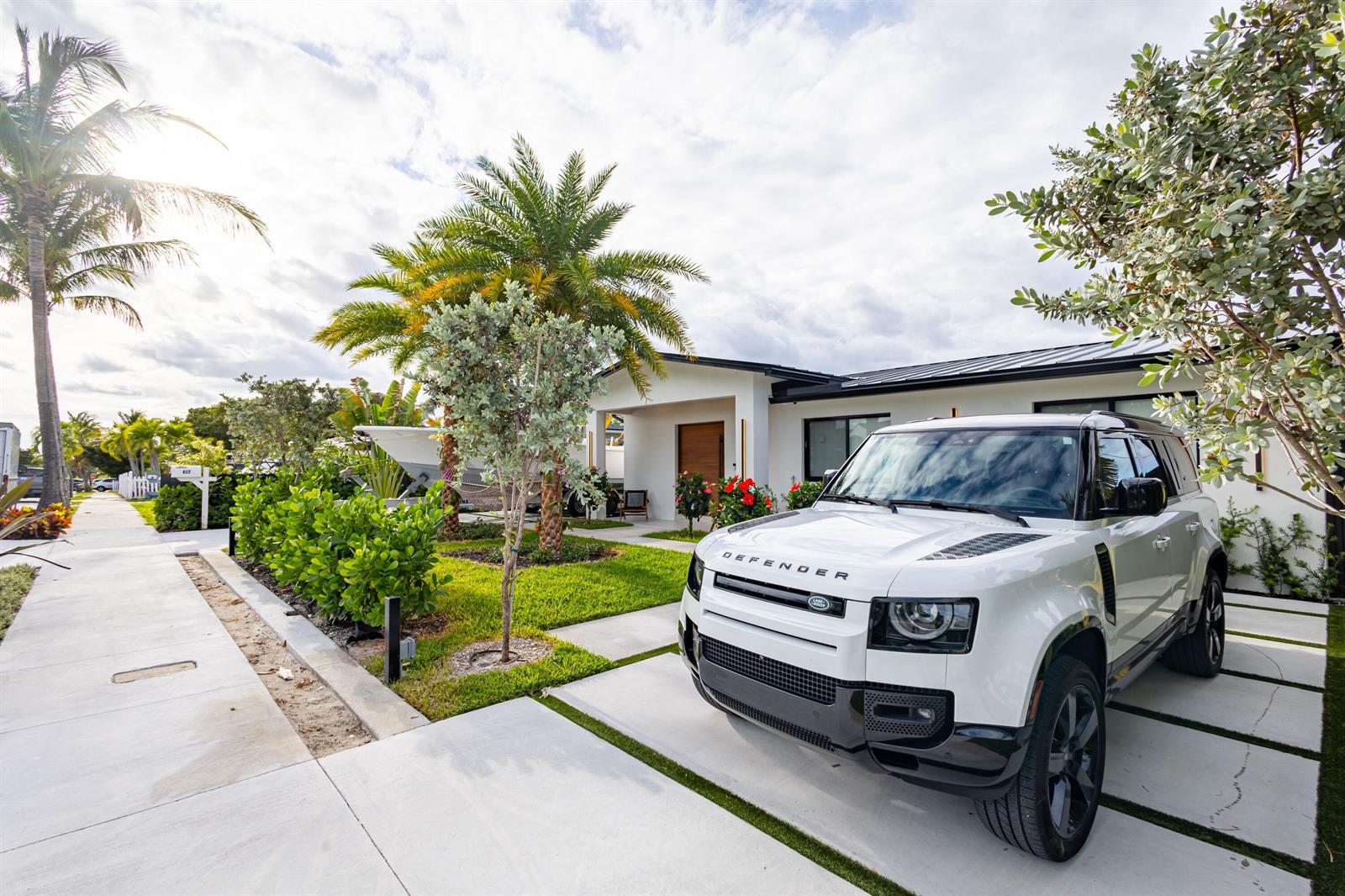 A white Land Rover Defender is parked in the driveway of a modern single-story house — 807 Hollywood Place, West Palm Beach FL 33405, WEST PALM BEACH, FL