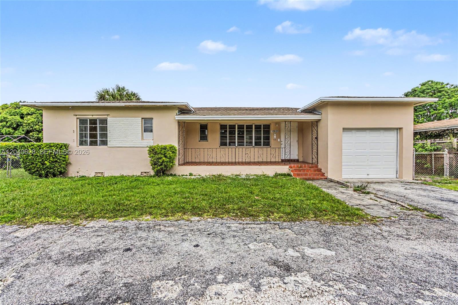 A single-story house with a beige exterior, a front porch, and an attached one-car garage — 13020 NW 1st Ave # x, Miami FL 33168, MIAMI, FL