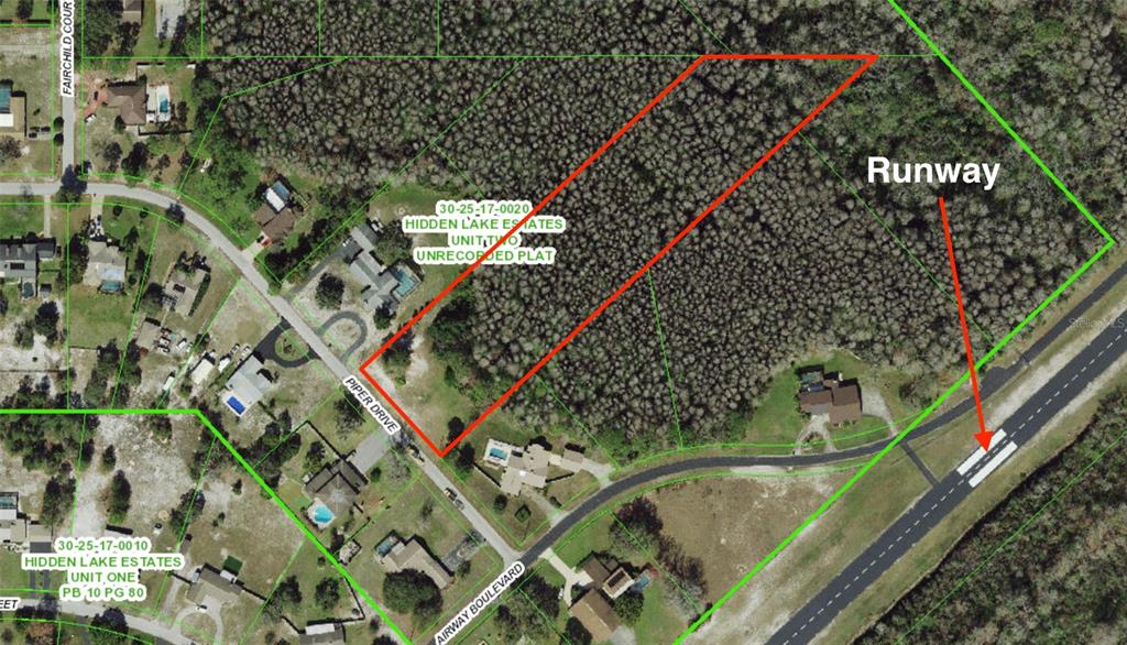 An aerial map shows a wooded residential lot outlined in red next to an airport runway — 0 PIPER DR, NEW PORT RICHEY, FL