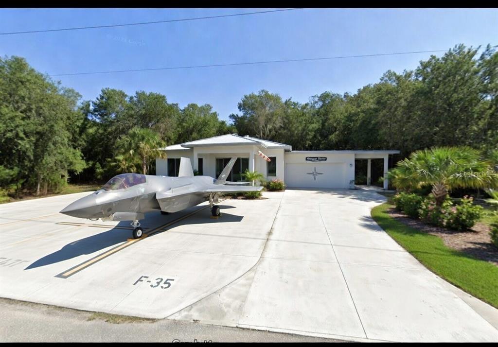 A single-story house with a driveway featuring a full-scale F-35 fighter jet model — 0 PIPER DR, NEW PORT RICHEY, FL