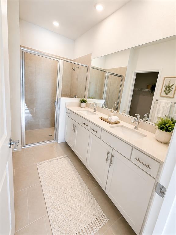 A modern kitchen features white cabinets, stainless steel appliances, and light-colored quartz countertops — 8212 SAINT KITTS CIRCLE, ENGLEWOOD, FL