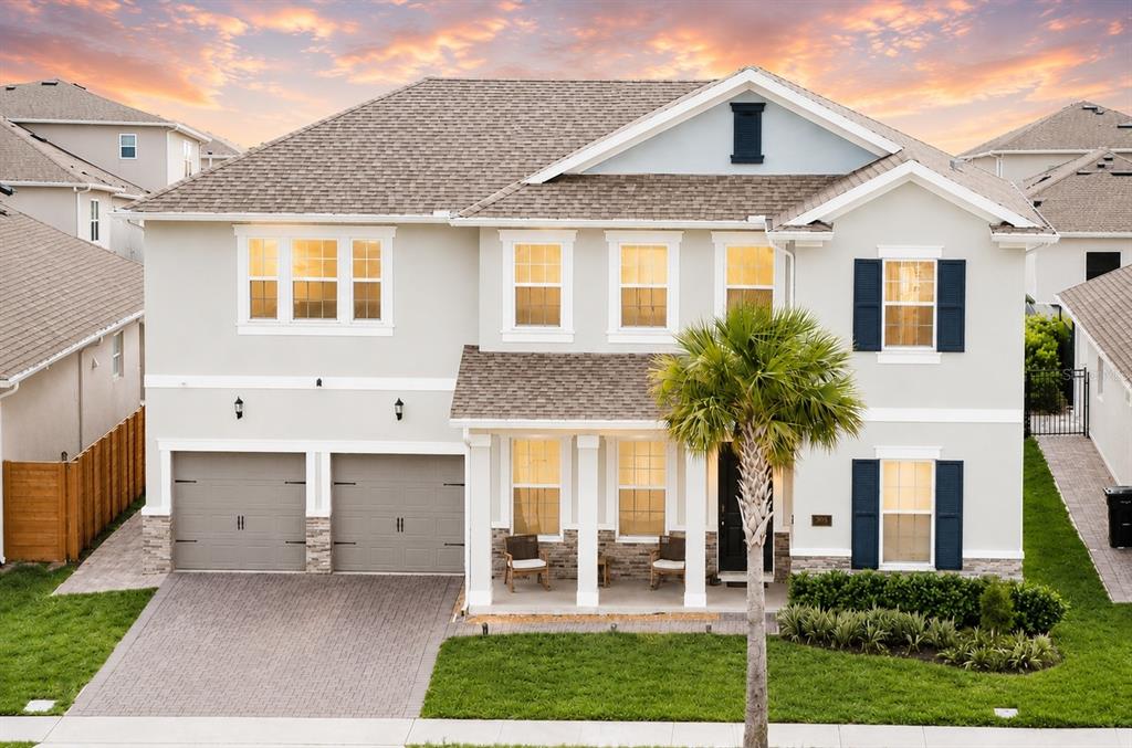 A two-story suburban home features a gray exterior, a two-car garage, and a palm tree — 19076 PLANETREE STREET, ORLANDO, FL